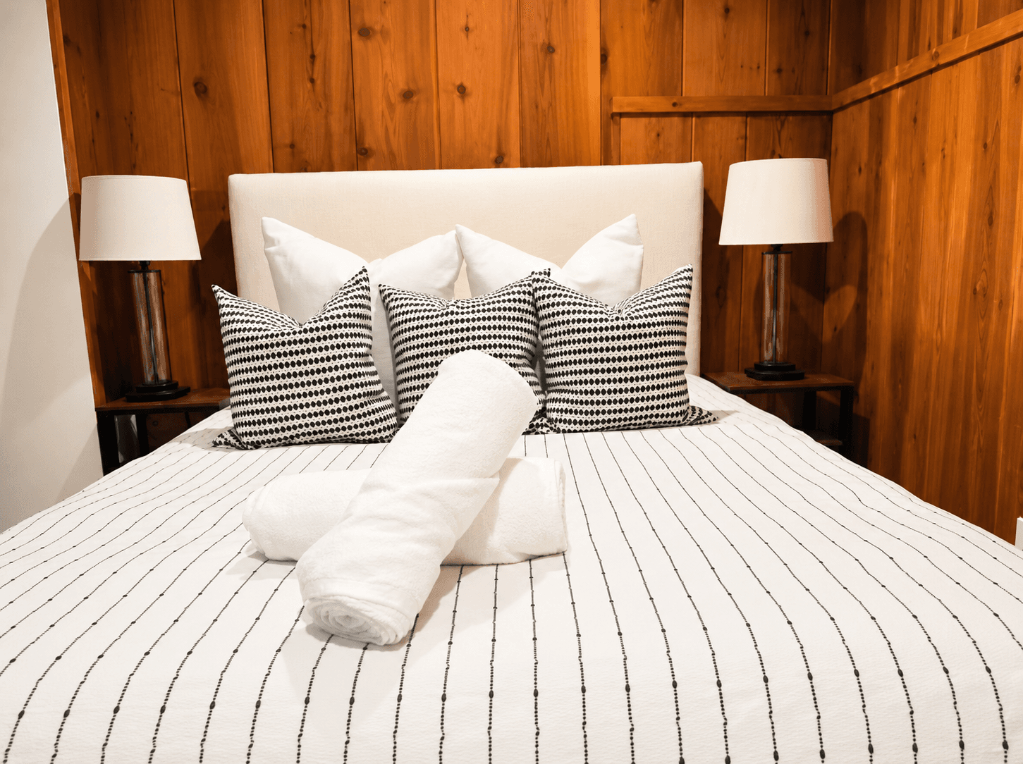 Bedroom made up with fresh linens, styled pillows, and rolled towels after a ShinySpaces turnover cleaning