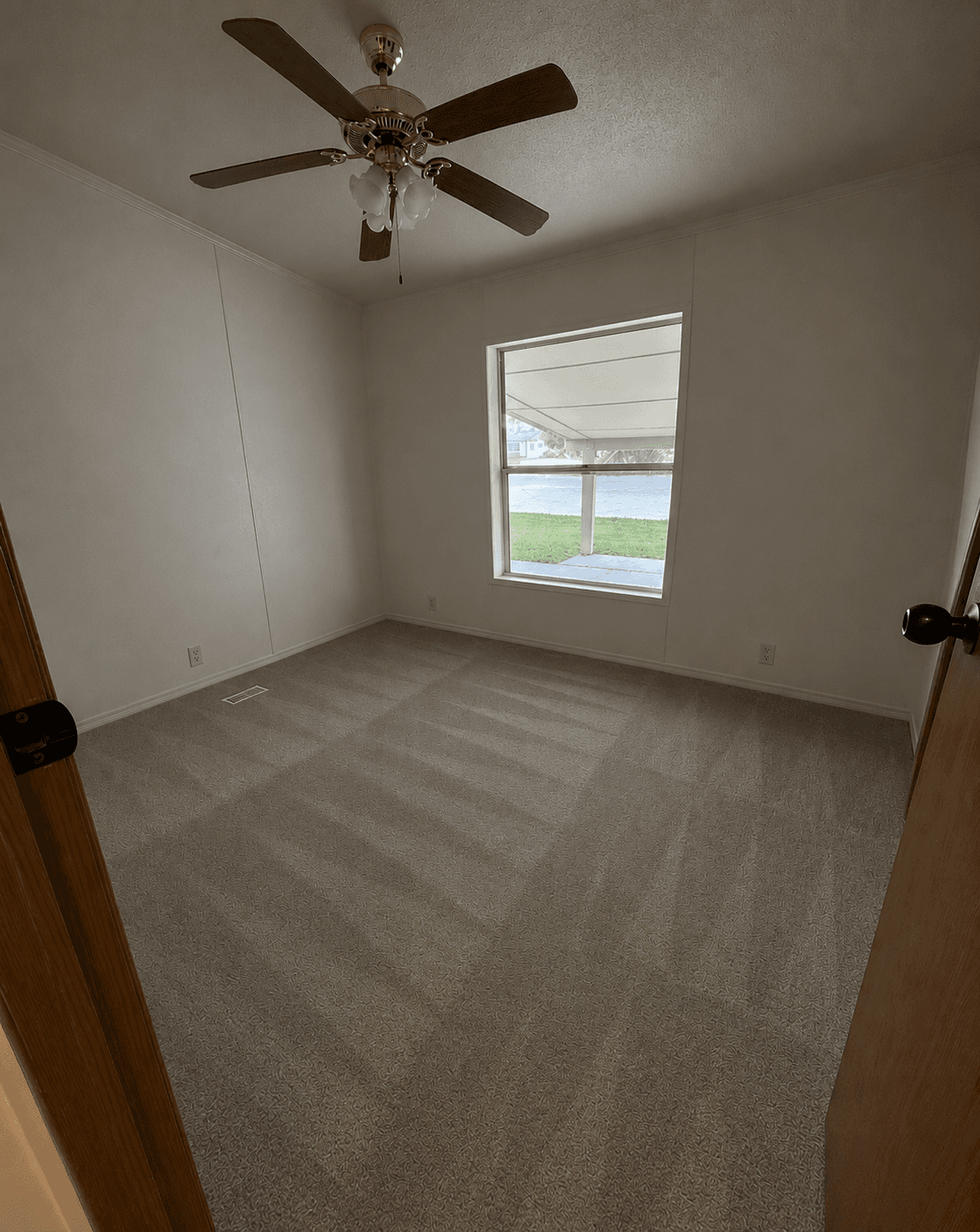 Empty bedroom with freshly vacuumed carpet after a ShinySpaces cleaning